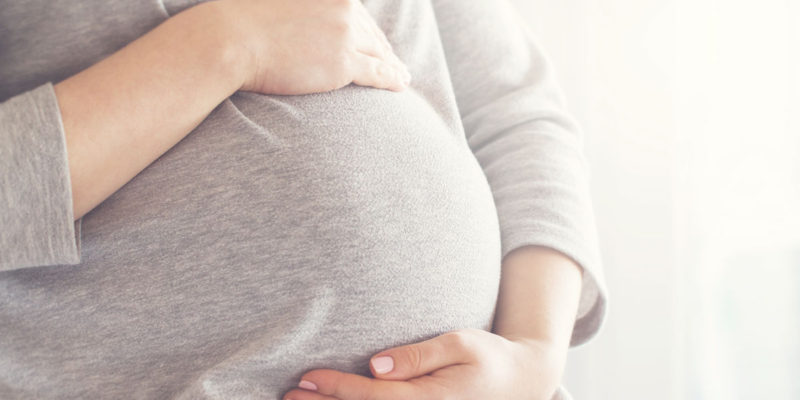 foto de uma grávida com as mãos na barriga