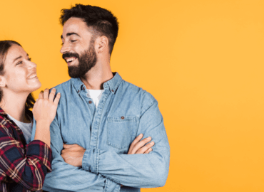 Foto de um casal se olhando, eles estão felizes e sorrindo