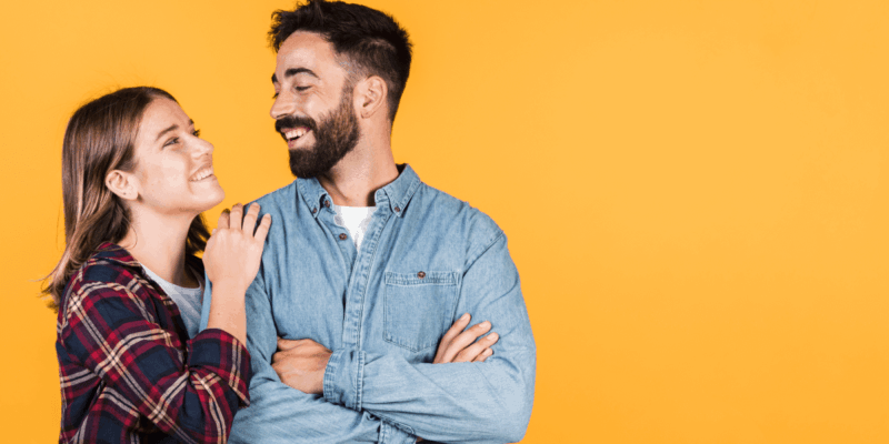 Foto de um casal se olhando, eles estão felizes e sorrindo